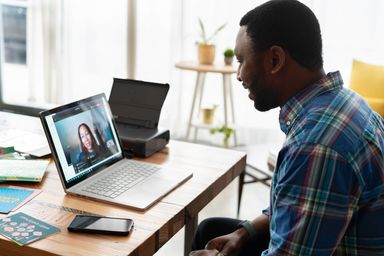 Two people on a video call on a laptop