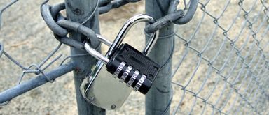 A picture of a padlock securing entry to a yard