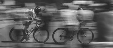 A picture of blurred cyclists implying high speed
