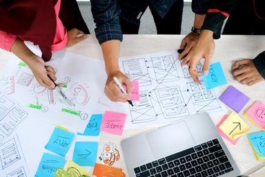 People drawing and writing on paper prototypes